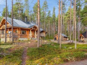 una cabaña de madera en el bosque con árboles en Holiday Home Peurankuoppa by Interhome, en Lemmenjoki