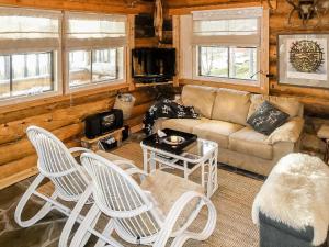 a living room with white chairs and a couch at Holiday Home Peurankuoppa by Interhome in Lemmenjoki +29 photos