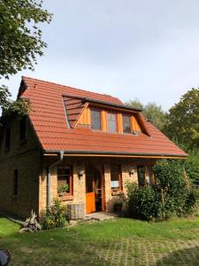 a brick house with an orange roof at Boddenblick in Groß Kordshagen