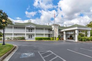 een groot wit gebouw met een parkeerplaats bij Quality Inn Fayetteville Near Historic Downtown Square in Fayetteville