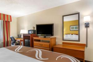 a hotel room with a bed and a flat screen tv at Quality Inn Fayetteville Near Historic Downtown Square in Fayetteville