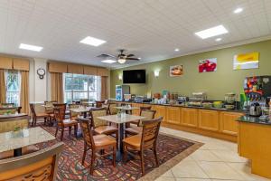 a restaurant with tables and chairs and a kitchen at Quality Inn Fayetteville Near Historic Downtown Square in Fayetteville