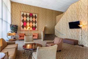 a lobby with a couch and chairs and a tv at Quality Inn & Suites - Greensboro-High Point in Greensboro