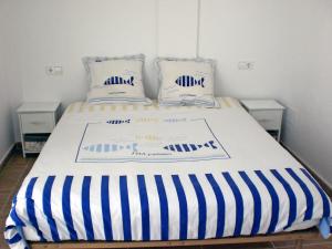 レスカラにあるHoliday Home Michele by Interhomeのベッド(青と白のストライプシーツ、枕付)