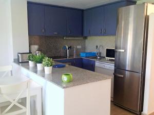 レスカラにあるHoliday Home Michele by Interhomeのキッチン(青いキャビネット、ステンレス製の冷蔵庫付)