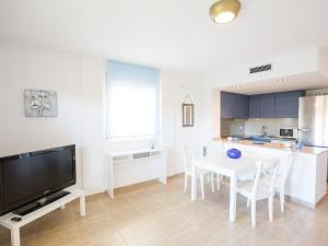 cocina y comedor con mesa y TV en Holiday Home Michele by Interhome, en L'Escala