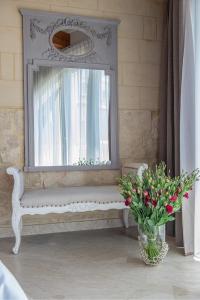 a white bench with a window and a vase of flowers at Lulu Boutique Hotel in Żebbuġ