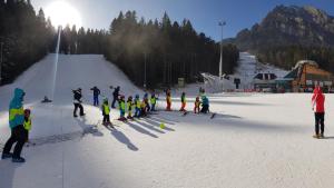 a group of people standing on a ski slope at Apartament Eric, Busteni in Buşteni