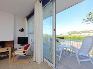 Habitación con balcón con sillas y TV. en Apartment AGUS by Interhome, en Port de la Selva