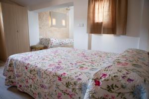 比亞爾的住宿－Casa rural RIUIVIU，一间卧室配有一张带鲜花毯子的床