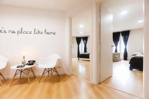 بي برشلونة بلازا كاتالونيا في برشلونة: غرفة معيشة بيضاء مع طاولة وكراسي
