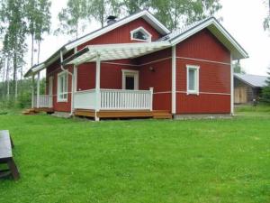 a red house with a green lawn in front of it at Holiday Home Helmiranta by Interhome in Saarijärvi