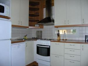 a kitchen with white cabinets and white appliances at Holiday Home Helmiranta by Interhome in Saarijärvi