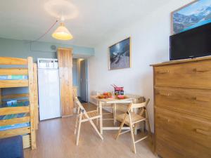 a room with a table and a kitchen with a refrigerator at Studio Soyouz Vanguard-78 by Interhome in Le Corbier