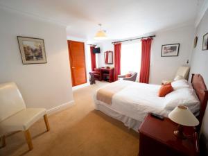 Habitación de hotel con cama y silla en The Rest and Be Thankful Inn en Minehead