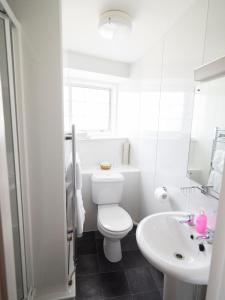 a white bathroom with a toilet and a sink at The Rest and Be Thankful Inn in Minehead