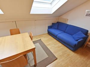 a living room with a blue couch and a table at Apartment Enrosadira-4 by Interhome in Alba di Canazei