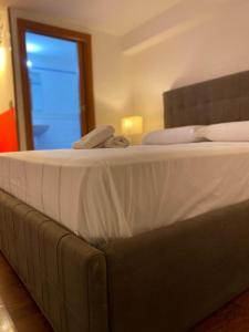 un grande letto con lenzuola e cuscini bianchi di Appartamenti Mergellina a Napoli