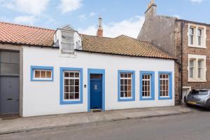 una casa blanca y azul con una puerta azul en Coastal Cottage - Cellardyke Anstruther, en Anstruther