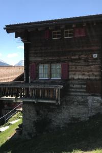 a log cabin with windows and a porch at Apartment Stubulti by Interhome in Mörel