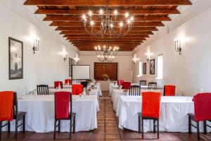 uma sala de jantar com mesas brancas e cadeiras vermelhas em Webersburg em Stellenbosch