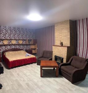 um quarto com uma cama, 2 cadeiras e uma mesa em Moskovs'kyi Avenue 80/82 em Kharkov