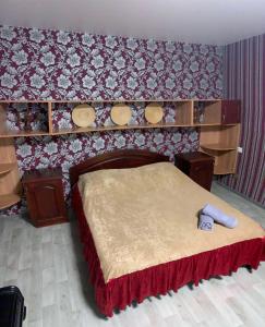 um quarto com uma cama com uma parede vermelha em Moskovs'kyi Avenue 80/82 em Kharkov