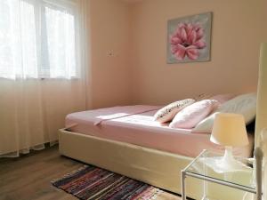 una camera da letto con letto e lenzuola e cuscini rosa di Apartment Vera Nin a Nin