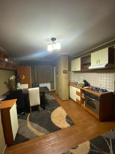 eine Küche und ein Wohnzimmer mit einem Tisch und einem Herd in der Unterkunft Friend's House in Piteşti