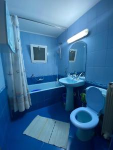 bagno blu con servizi igienici e lavandino di Friend's House a Piteşti