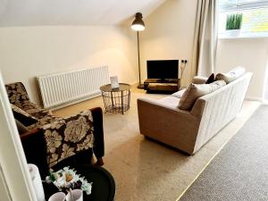 a living room with a couch and a tv at The Lamb and Flag Inn in Rhayader