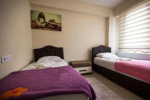 a bedroom with two beds with purple blankets and a window at Otel 22 Edirne in Edirne