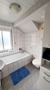 een badkamer met een bad, een toilet en een wastafel bij Ferienwohnungen Claudia in Altossiach