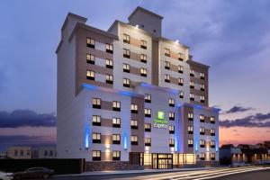 un grande edificio bianco con luci blu sopra di Holiday Inn Express - Jamaica - JFK AirTrain - NYC, an IHG Hotel a Queens