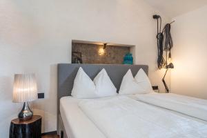 een slaapkamer met 2 bedden en witte kussens bij berg und tal - schlosserhaus 31 in Tesimo