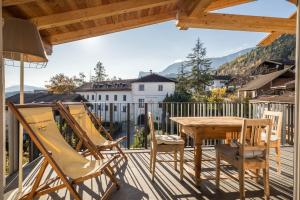 een terras met een houten tafel en stoelen bij berg und tal - schlosserhaus 31 in Tesimo