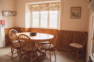 a dining room with a table and chairs and a window at Garden Cottage, Fochabers in Fochabers