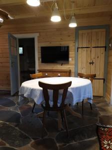 a room with a table and a television in a cabin at Domek Moczykija in Szypliszki