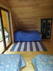 a bedroom in a log cabin with two beds at Domek Moczykija in Szypliszki