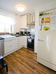 a kitchen with white cabinets and a white refrigerator at Ostseestrandliebe Villa Sanddorn Nr2 in Börgerende-Rethwisch