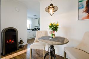 a dining room with a table and a fireplace at Ostseestrandliebe Villa Sanddorn Nr2 in Börgerende-Rethwisch