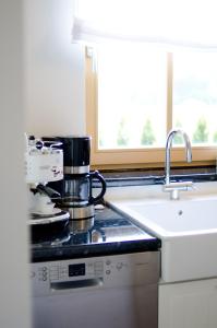 a kitchen with a sink and a coffee maker on a stove at Ostseestrandliebe Villa Sanddorn Nr2 in Börgerende-Rethwisch
