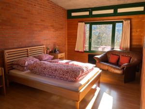 a bedroom with a bed and a couch and a window at Lovell Camps - Mountain Lodge in Gstaad