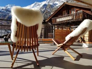 dos sillas con piel de imitación sentadas en un patio en Britannia - Apartment Patagonia en Saas-Fee