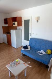 a living room with a blue couch and a table at Résidence les Alcyons in Le Verdon-sur-Mer