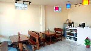 a restaurant with two tables and chairs and a counter at Titans House Chiang Dao in Chiang Dao