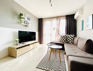 a living room with a couch and a tv at К's City Living with Free Parking in Plovdiv