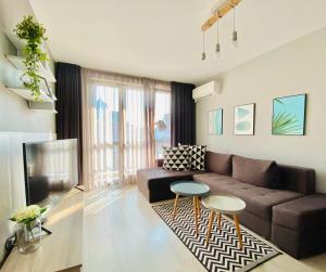 uma sala de estar com um sofá castanho e uma televisão em К's City Living with Free Parking em Plovdiv