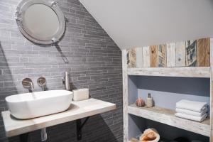 uma casa de banho com um lavatório e um espelho em The Harbour Retreat em Birdham