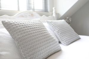 Una cama blanca con dos almohadas blancas. en The Harbour Retreat, en Birdham